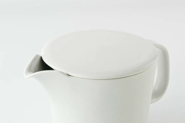 Light grey ceramic teapot with lid on a light gray background