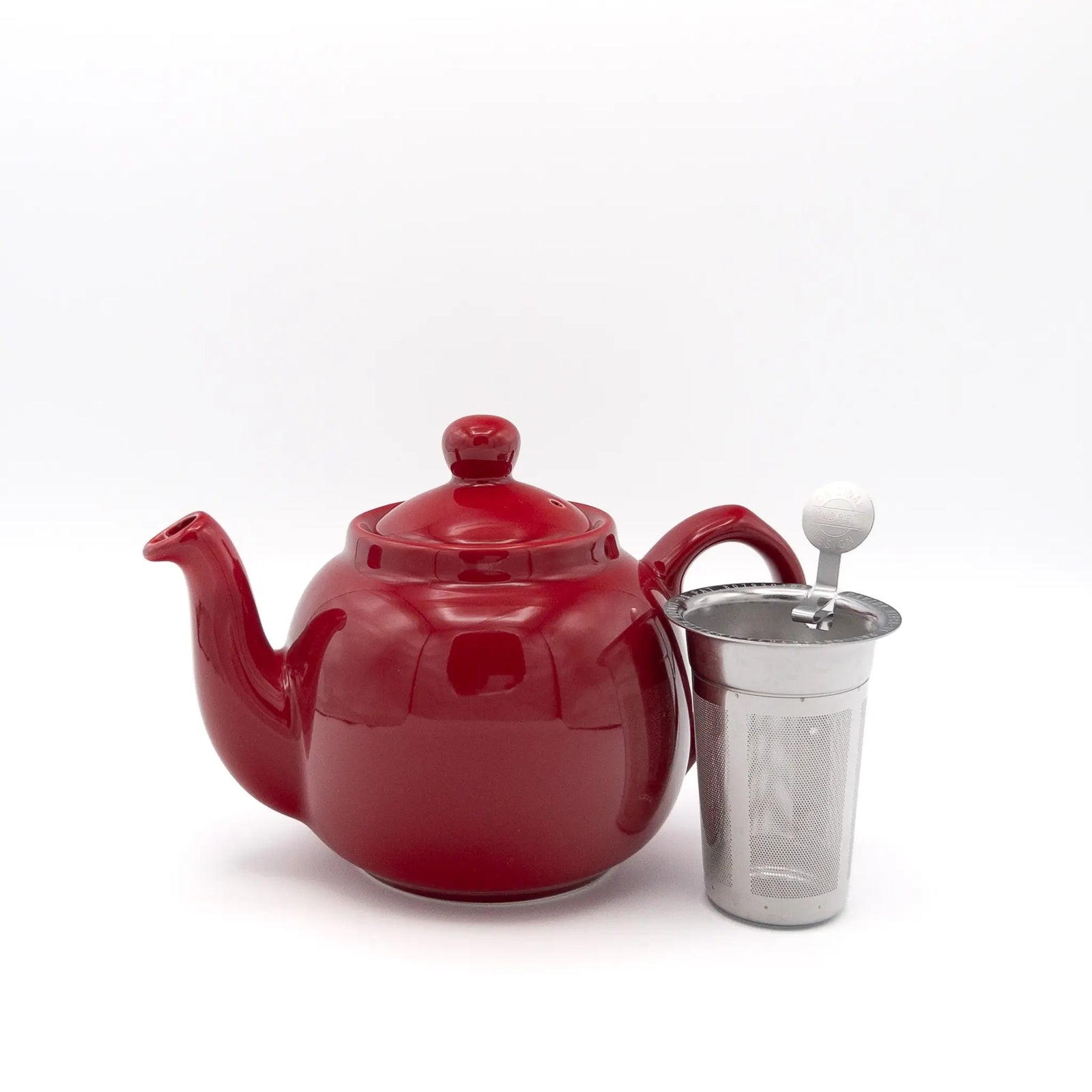A glossy red ceramic teapot with a matching lid and a stainless steel infuser set against a plain white background.