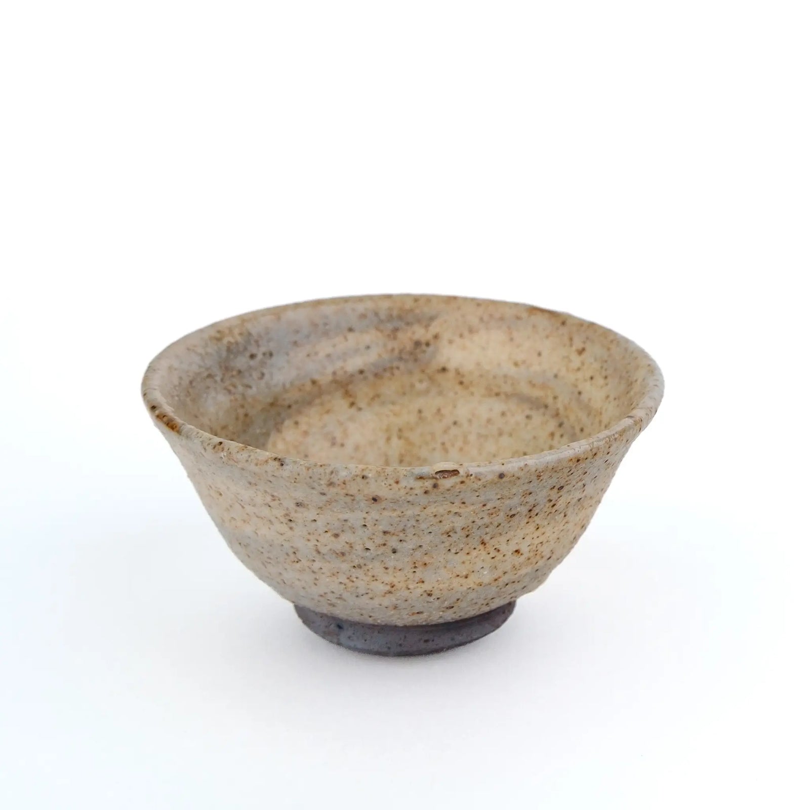 A handmade ceramic gong fu teacup with a textured, speckled glaze in earthy beige and brown tones, set against a plain white background - another side view