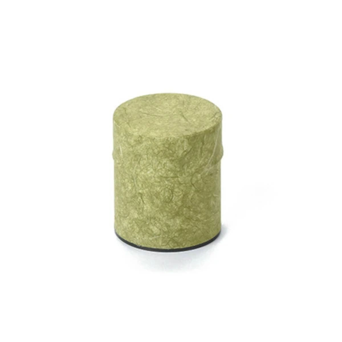 Green cylindrical tea caddie on a white background