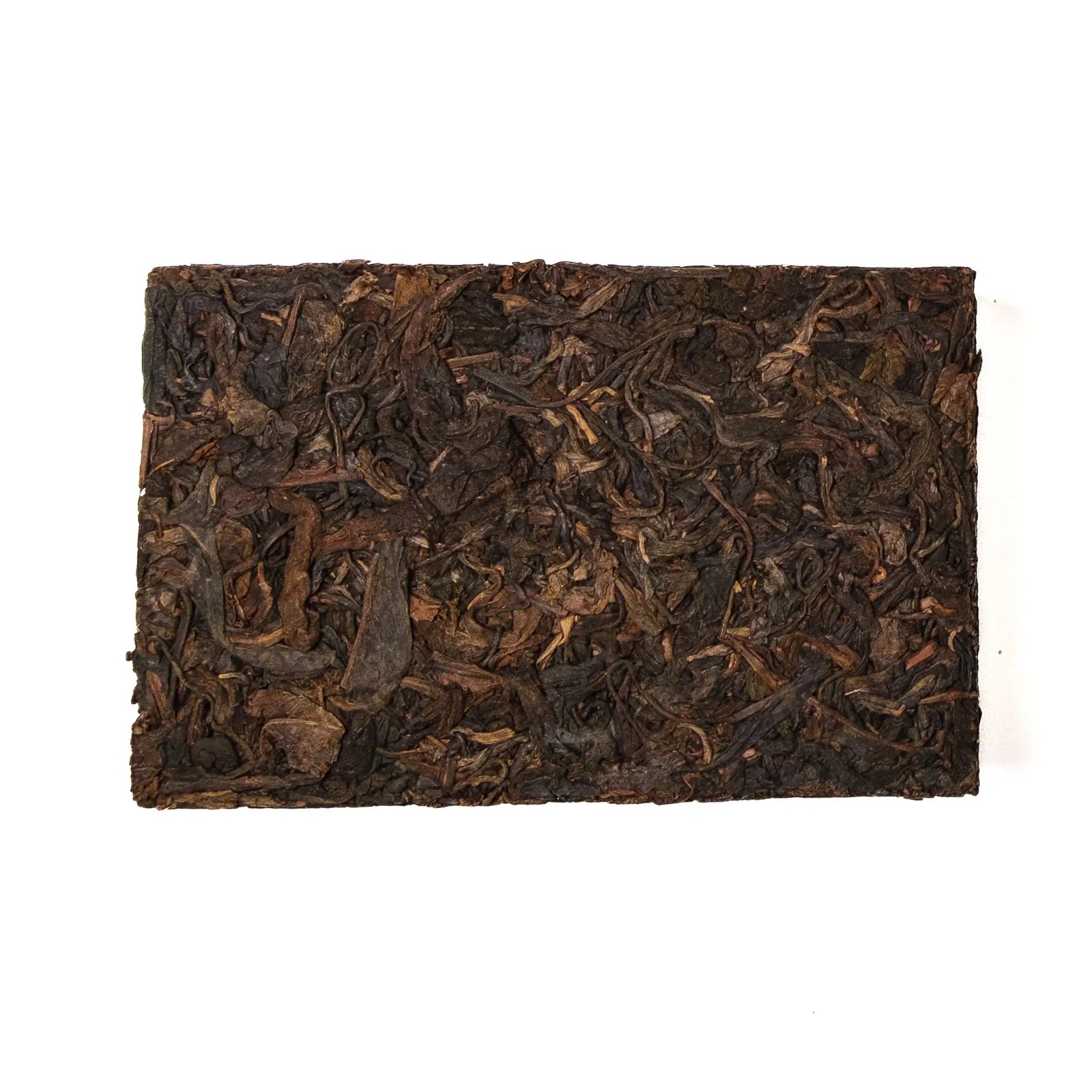 Rectangular block of dark brown tea leaves on a white background