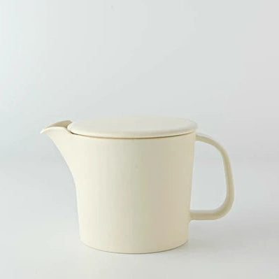 White ceramic teapot with a lid on a light gray background