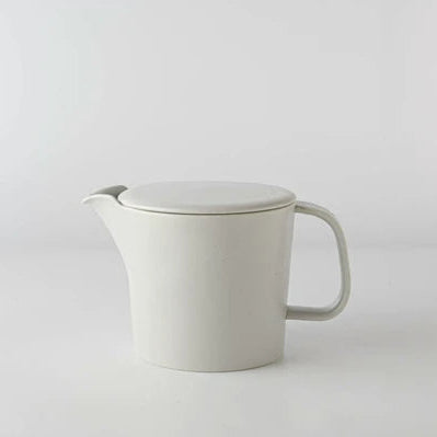 Light grey ceramic teapot with lid on a light gray background
