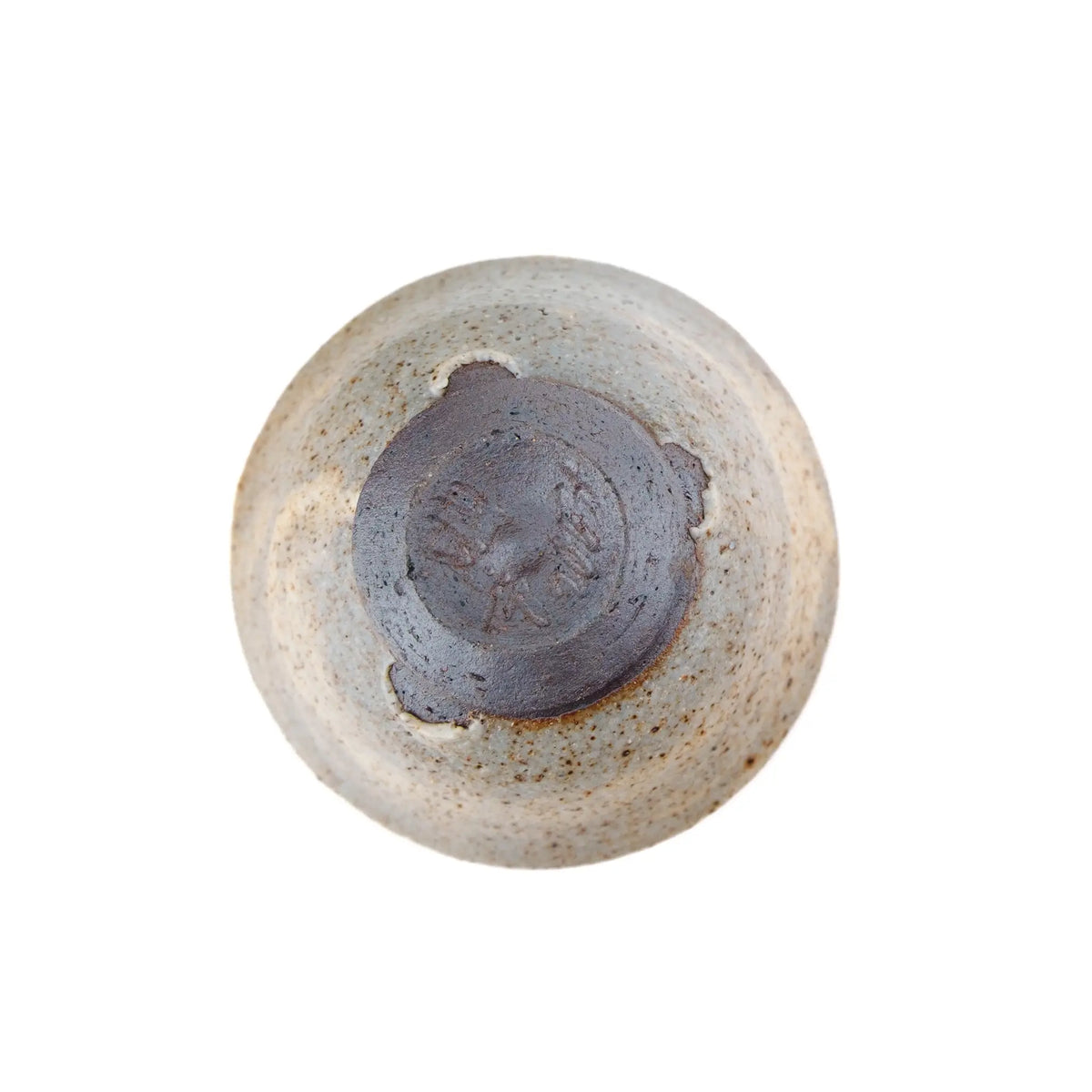 A handmade ceramic gong fu teacup with a textured, speckled glaze in earthy beige and brown tones, set against a plain white background - view of the underside